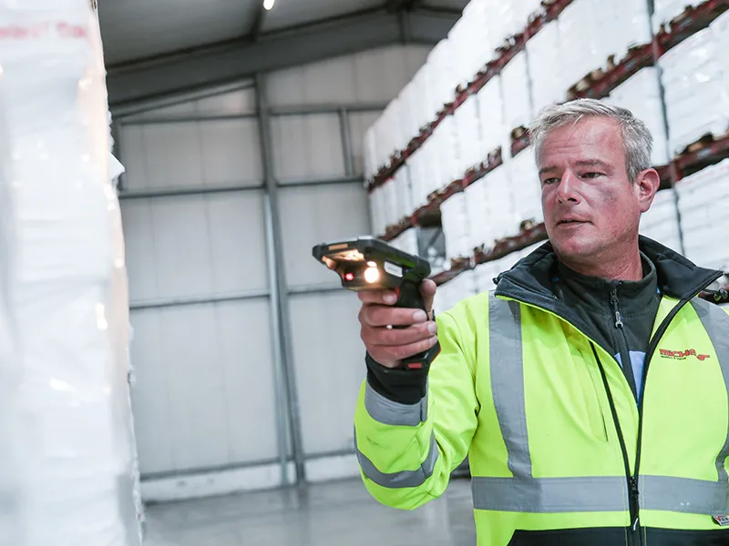 Barcodescanner Lager Mitarbeiter Warnweste Paletten Lagerwand