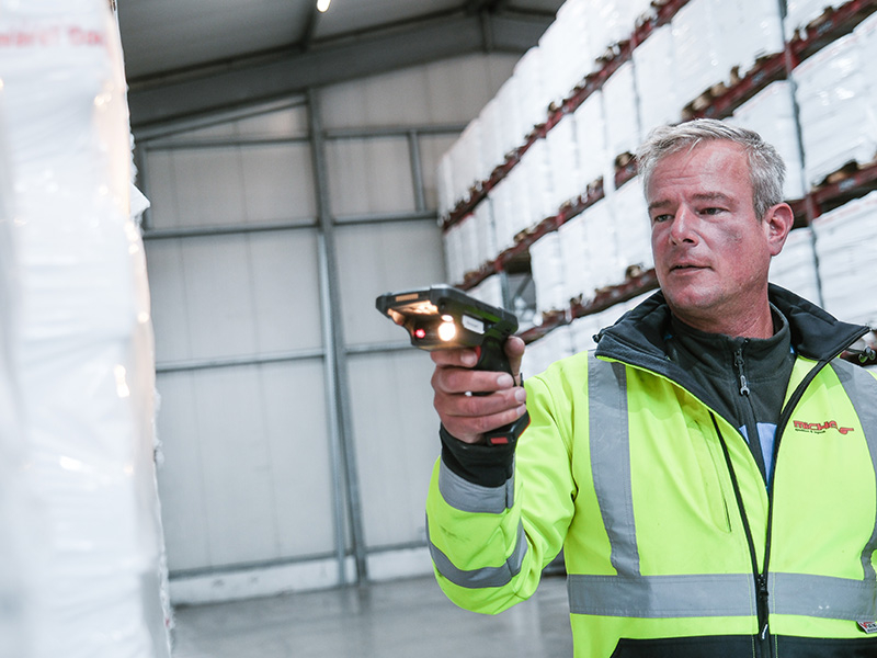 Barcodescanner Lager Mitarbeiter Warnweste Paletten Lagerwand